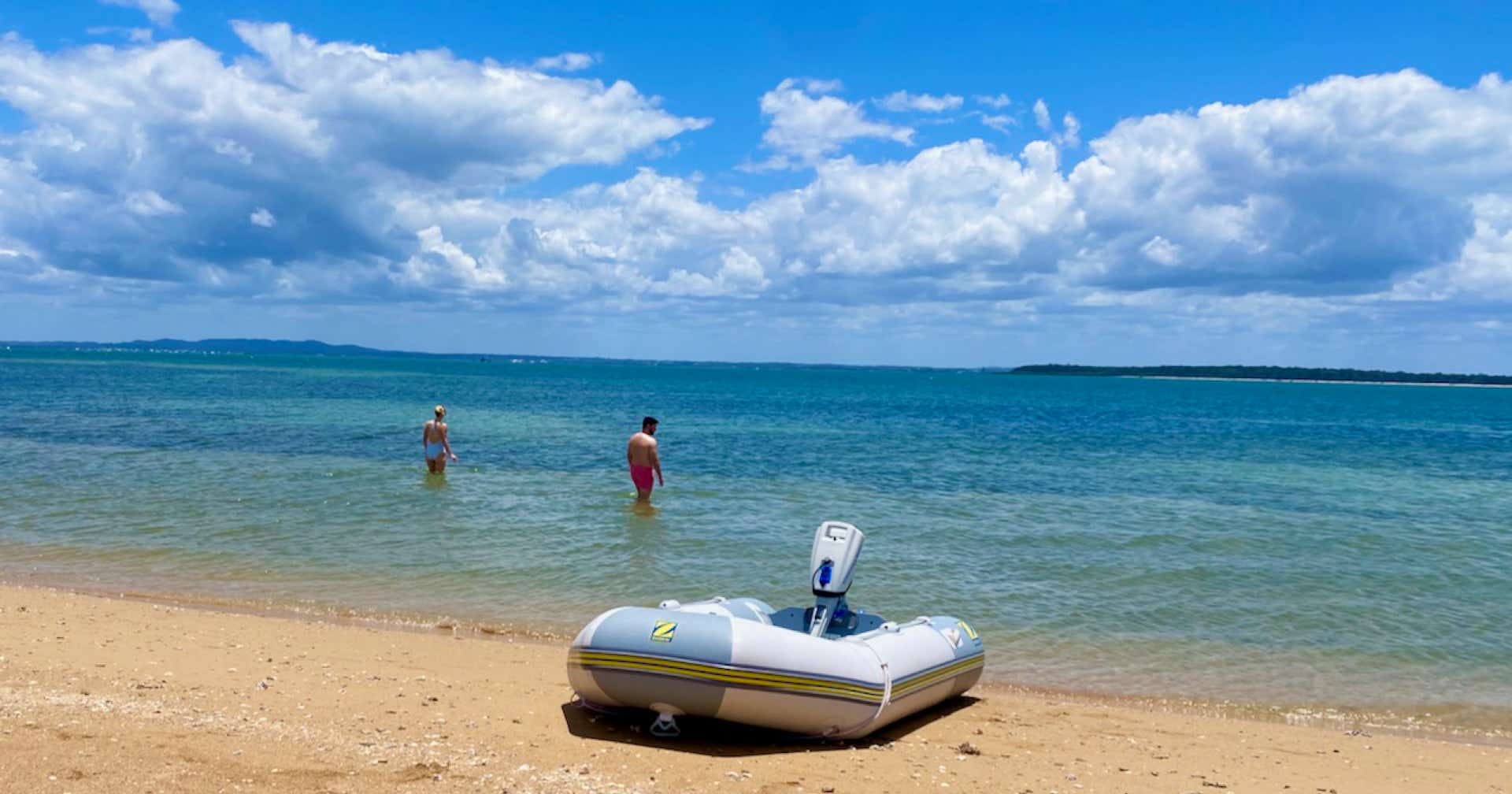 Guests swimming at Bird Islet Sandbar on sailing yacht Curlew Escape on a private yacht charter at Moreton Bay, Brisbane.