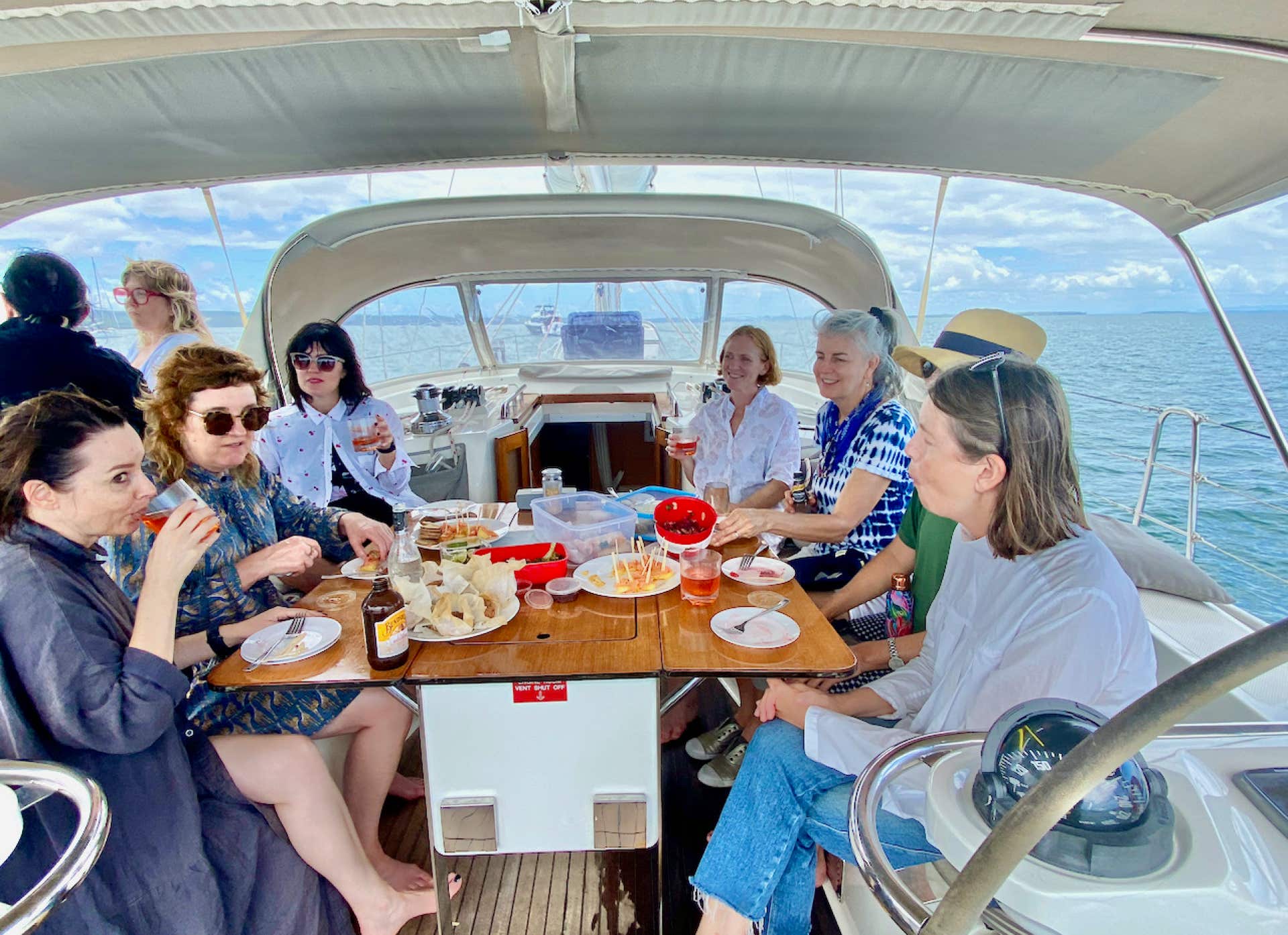 Ladies dining around the cockpit table on a sailing charter at Peel Island, Moreton Bay, Brisbane