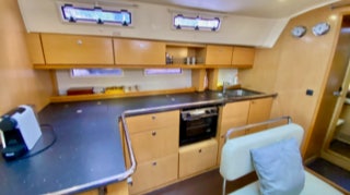 Saloon kitchen with oven, Nespresso coffee machine and sink.  on  Sailing Yacht Curlew Escape, available for private yacht charters on Moreton Bay, Brisbane.