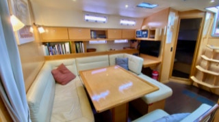 Comfy saloon with leather sofa and smart TV  on  Sailing Yacht Curlew Escape, available for private yacht charters on Moreton Bay, Brisbane.